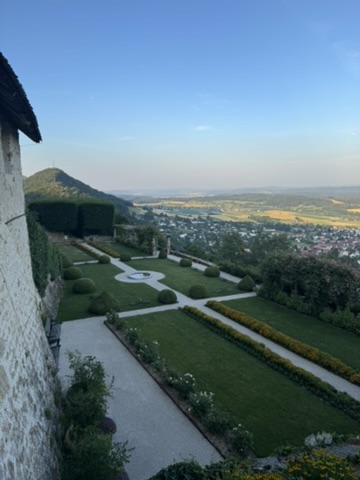 The castle garden with trimmed hedges and the valley far below.