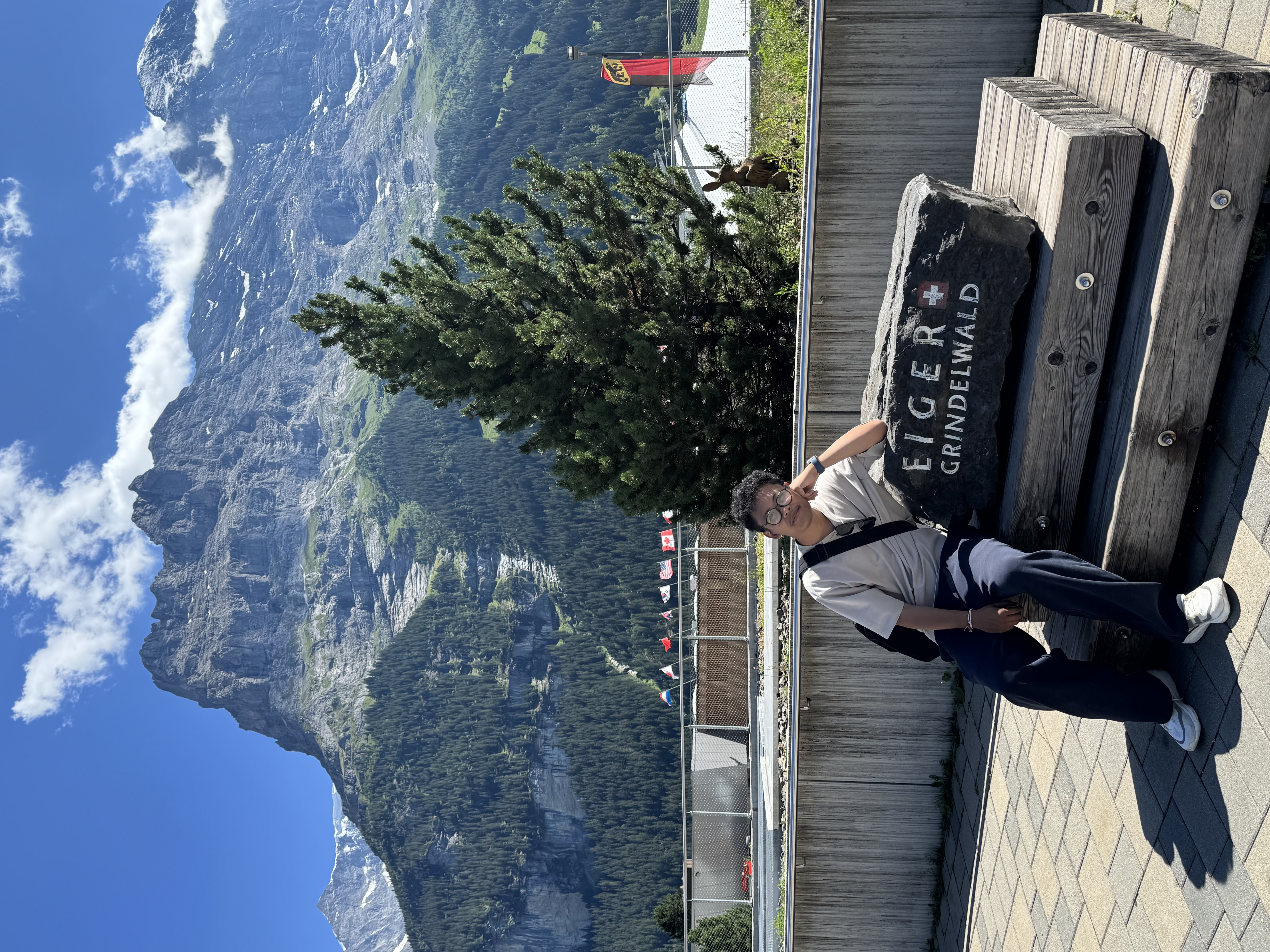 Me and the Eiger — leaning on the stone, staring up.
